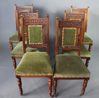 A set of 6 Edwardian carved walnut show frame dining chairs, the seats and backs upholstered in green material raised on turned supports 