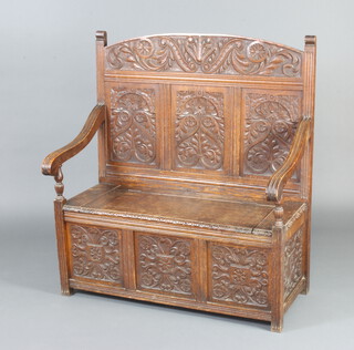 A Victorian carved oak settle with arch shaped back, raised on square supports 117cm h x 106cm w x 54cm d 