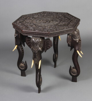 An Indian carved ebony octagonal occasional table raised on elephant supports 63cm h x 61cm w x 61cm d 