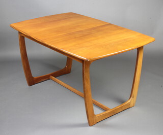 A mid 20th Century teak Astro style extending dining table with concealed extra leaf, raised on shaped supports with H framed stretcher 71cm h x 88cm w x 135cm l x 180cm l when extended.  The concealed extra leaf has an impressed mark 75 
