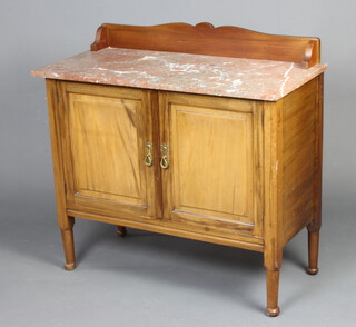 An Edwardian walnut wash stand with raised back and pink veined marble top enclosed by a pair of panelled doors, raised on turned supports 88cm h x 91cm w x 43cm d 