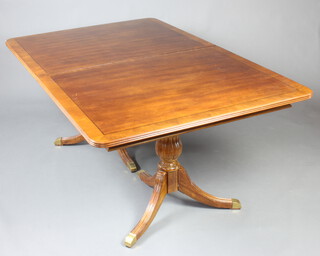 A Georgian style cross banded mahogany extending dining table with 2 extra leaves, raised on twin pillar pedestal and tripod supports  74cm h x 112cm w x 173cm l when closed x 249cm l when extended 