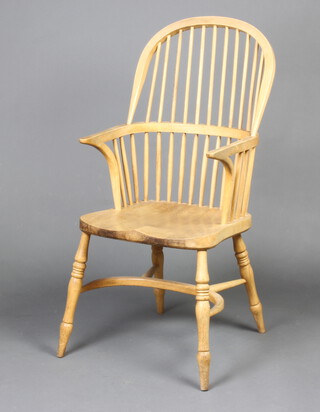 A 20th Century elm and beech stick and rail back carver chair with crinoline stretcher, raised on turned supports