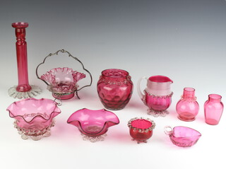 A Victorian cranberry glass candlestick, a collection of cranberry bowls and vases 