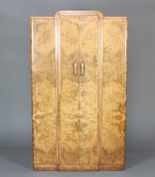 An Art Deco arch shaped figured walnut wardrobe with fitted interior enclosed by a pair of panelled doors 172cm h x 99cm w x 50cm