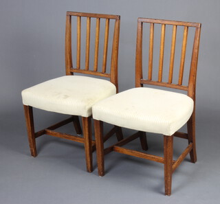 A pair of 19th Century mahogany stick and rail back dining chairs with over stuffed seats, raised on square tapered supports with H framed stretcher 