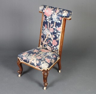 A Victorian mahogany show frame prie-dieu chair upholstered in blue floral material, raised on cabriole supports 