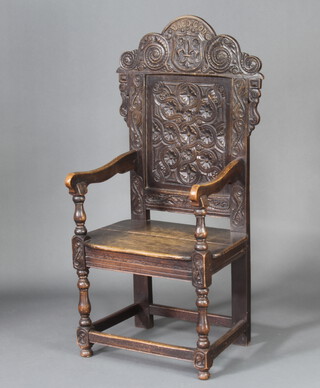 A Victorian carved oak Wainscot chair, the arched crest marked Dred God, raised on turned and block supports 