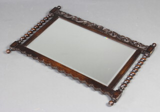 A 1930's rectangular bevelled plate wall mirror contained in a carved and pierced oak frame with spiral turned decoration 63cm h x 87cm w 