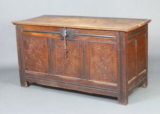 A 17th/18th Century carved oak coffer of panelled construction with hinged lid, the interior fitted a candle box, having an iron lock complete with key 70cm h x 121cm w x 56cm d 