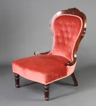 A Victorian mahogany framed nursing chair upholstered in pink buttoned dralon, raised on turned supports (frame is loose)