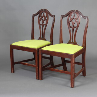 A pair of Hepplewhite style mahogany dining chairs with upholstered drop in seats raised on square supports