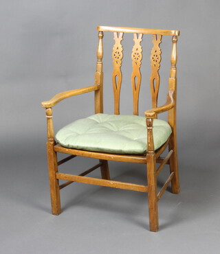 A beech framed open arm stick and wheel back chair with woven cane seat
