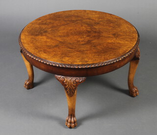 A circular Queen Anne style figured walnut occasional table with quarter veneered top, gadrooned border, raised on cabriole supports, paw feet 40cm h x 69cm w, the base labelled Beresford and Hicks, London, England