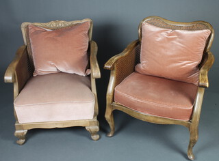 A 1950's bleached mahogany Georgian style show frame single cane bergere armchair with carved cresting rail, raised on cabriole supports together with a similar bergere chair 
