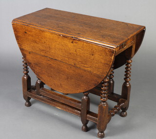 A 17th/18th Century oak drop flap gateleg tea table, fitted a frieze drawer raised on bobbin turned supports 69cm h x 81cm w x 40cm when closed x 122cm l when open 