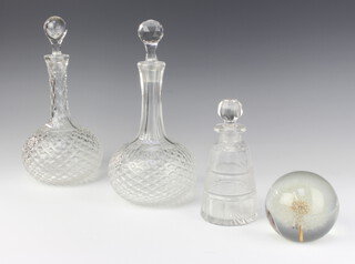 A near pair of moulded glass decanters, a faceted glass scent and a paperweight 
