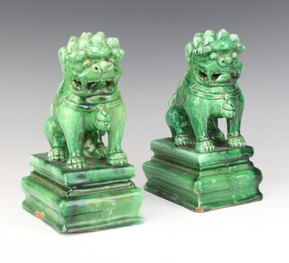 A pair of Chinese green glazed figures of Shi Shi on rectangular bases 20cm 