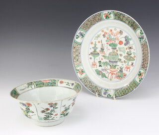 A 19th Century Chinese famille vert bowl decorated with panels of flowers and insects 18.5 cm, ditto plate the centre with vases of flowers, frog, writing materials and parasols 25cm 