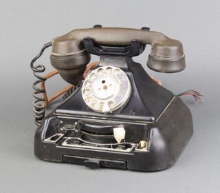 A black Bakelite telephone, the base incorporating a switchboard panel marked exchange, extension, etc 