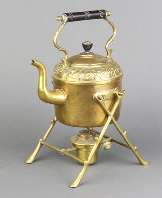 An Art Nouveau circular embossed brass spirit kettle raised on a crabstock supports, complete with burner 