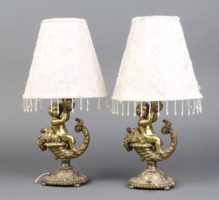 A pair of gilt metal table lamps in the form of cherubs sat upon a cornucopia 19cm h x 7cm diam. 