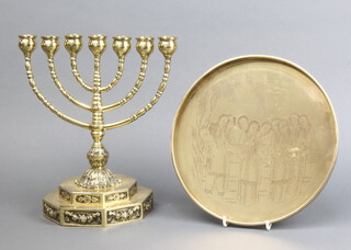 A late 19th early 20th Century brass Menorah raised on a stepped octagonal base 27cm x 15cm and a circular 19th/20th Century Chinese gilt metal tray engraved Geishas 1cm x 24cm 