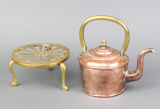 A circular copper kettle with acorn brass finial and handle 12cm x 11cm together with a circular pierced brass trivet 8cm x 16cm 