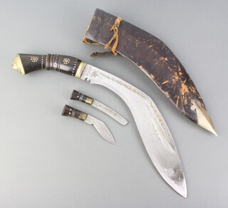 A Kukri, the blade marked India Mandicraft with horn grip and leather scabbard complete with 2 skinning knives 