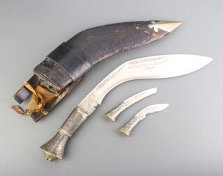 A Kukri, the blade marked India Handcrafted centre, the "silver" grip with lion mask decoration complete with 2 skinning knives  and scabbard