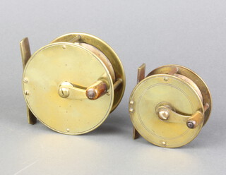 A 19th Century brass fishing reel with turned wooden handle 7cm and 1 other 6cm with turned wooden handle  