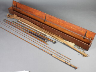 A Farlows 3 section fly fishing rod with timber let in, in cloth bag, a bamboo 3 section fishing rod with ceramic eyes, a turned wooden twin section boat rod with cloth bag, all contained in a rectangular mahogany rod transport case  