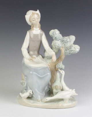A Nao group of a seated lady feeding geese beside a tree 30cm 