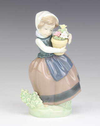 A Lladro figure of a girl holding a pot of flowers 5223 17cm 