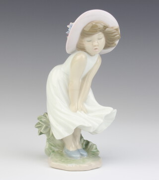 A Lladro figure of a girl with a floral hat 