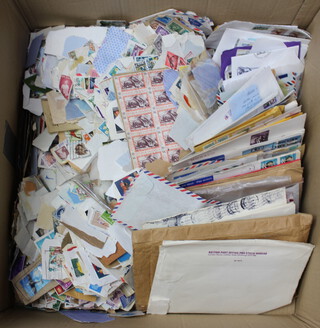 A quantity of stamped envelopes and world stamps contained in a large cardboard box 