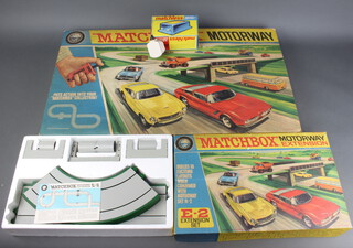 A Lesney Matchbox motorway M2 together with ditto motorway extension E2 and a UK 1 ten volt power back 