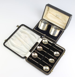A pair of silver napkin rings Birmingham 1942 cased and a set of 6 bean end silver coffee spoons Birmingham 1956, 106 grams