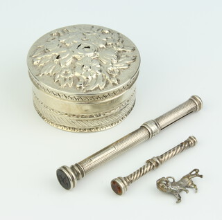 A Continental repousse silver circular box decorated with flowers 12.5cm, 2 pencils and a charm