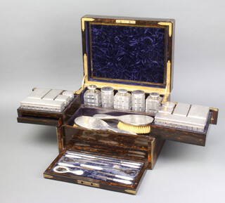 A fine Victorian brass inlaid coromandel toilet box containing 6 silver topped cut glass boxes, 7 silver topped cut glass bottles and a silver topped inkwell - all London 1861 maker TW, a silver mounted powder box London 1892 maker GB. GWR. JB, 2 silver mounted hair brushes London 1855 maker WN, all engraved with formal scrolls and monogrammed CA, the fall front containing 9 mother of pearl mounted implements, 2 pairs of steel scissors, a steel thimble and a S Mordan & Co propelling pencil.  Having 3 secret drawers, the base drawer being released by a faux screw (inoperable), the lock by J Bramah with key  23cm h x 35.5cm w x 27.5 d
