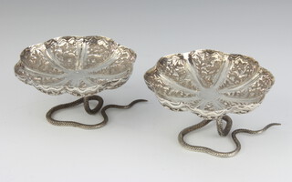 A pair of Indian repousse silver table salts decorated with animals, raised on cobra bases 6cm, 196 grams 