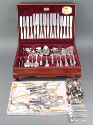A mahogany canteen containing a set of beaded cutlery for 8 together with a quantity of souvenir spoons and cutlery