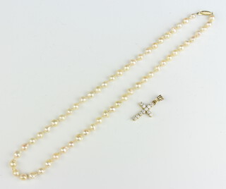 A string of cultured pearls with a gold clasp and a gold gem set cross pendant 