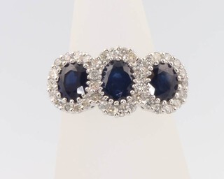 An 18ct white gold triple sapphire and diamond cluster ring, the brilliant cut diamonds approx. 0.7ct, the oval cut sapphires approx. 1.88ct, size N
