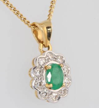 An 18ct yellow gold oval emerald and diamond cluster pendant, the centre oval cut stone approx. 1ct, the brilliant cut stones approx. 0.3ct, 15mm on a 44cm chain