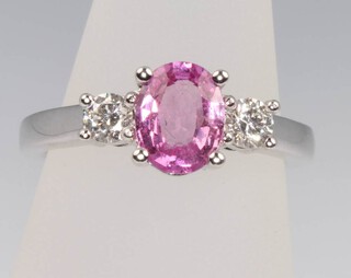 An 18ct white gold oval pink sapphire and diamond ring, the centre stone 1.5ct, the diamonds 0.3ct, size L 1/2