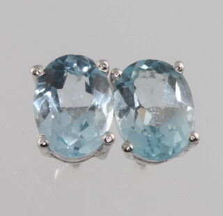 A blue of silver and blue topaz ear studs 