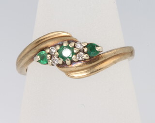 A 9ct yellow gold emerald and diamond crossover ring, size P, 2.8 grams 