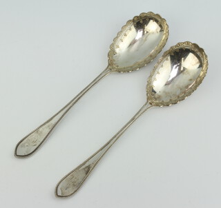 A pair of Victorian silver chased serving spoons London 1897, 195 grams