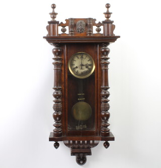 A Vienna style  striking regulator with silvered dial, Roman numerals, contained in a carved walnut case 